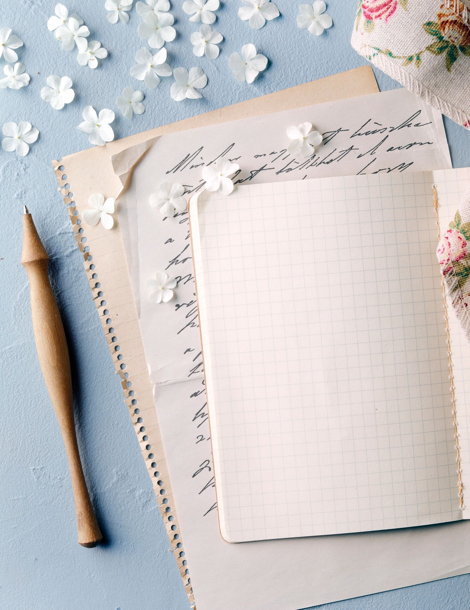 Vintage letter and blank notebook arranged with flowers